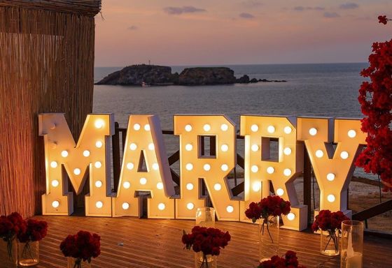 Infissi a neon personalizzati illuminano le lettere per la festa di nozze
